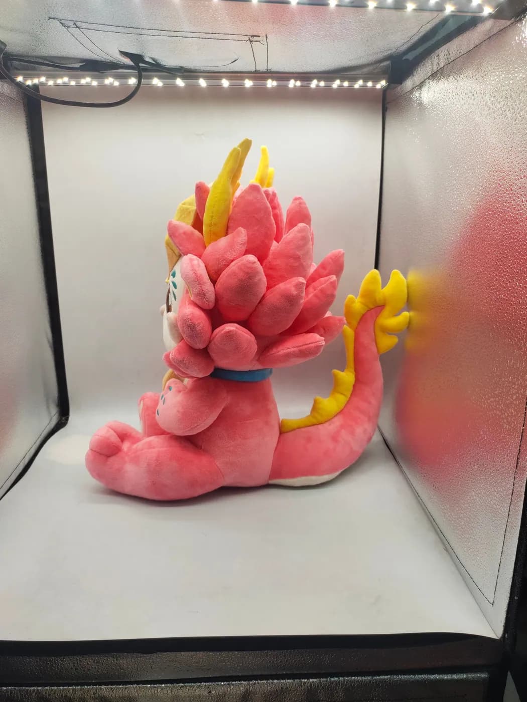 Coiled pink dragon plush toy with a long-pile mane