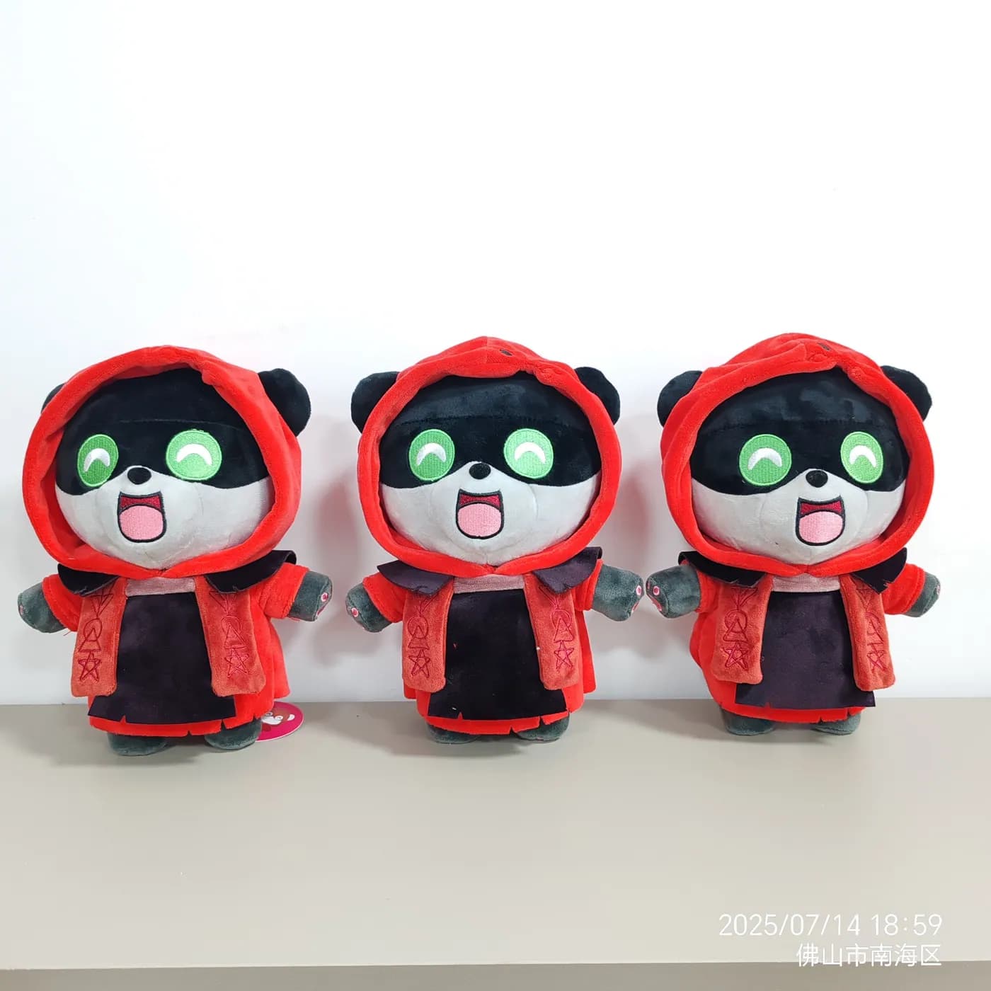 Three panda plush toys in red hooded capes from one production run