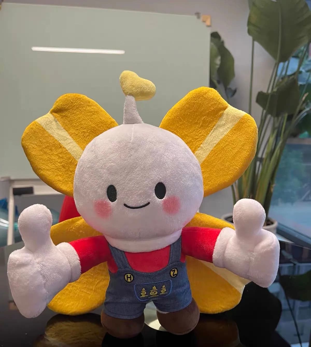 Butterfly character mascot plush in printed dungarees